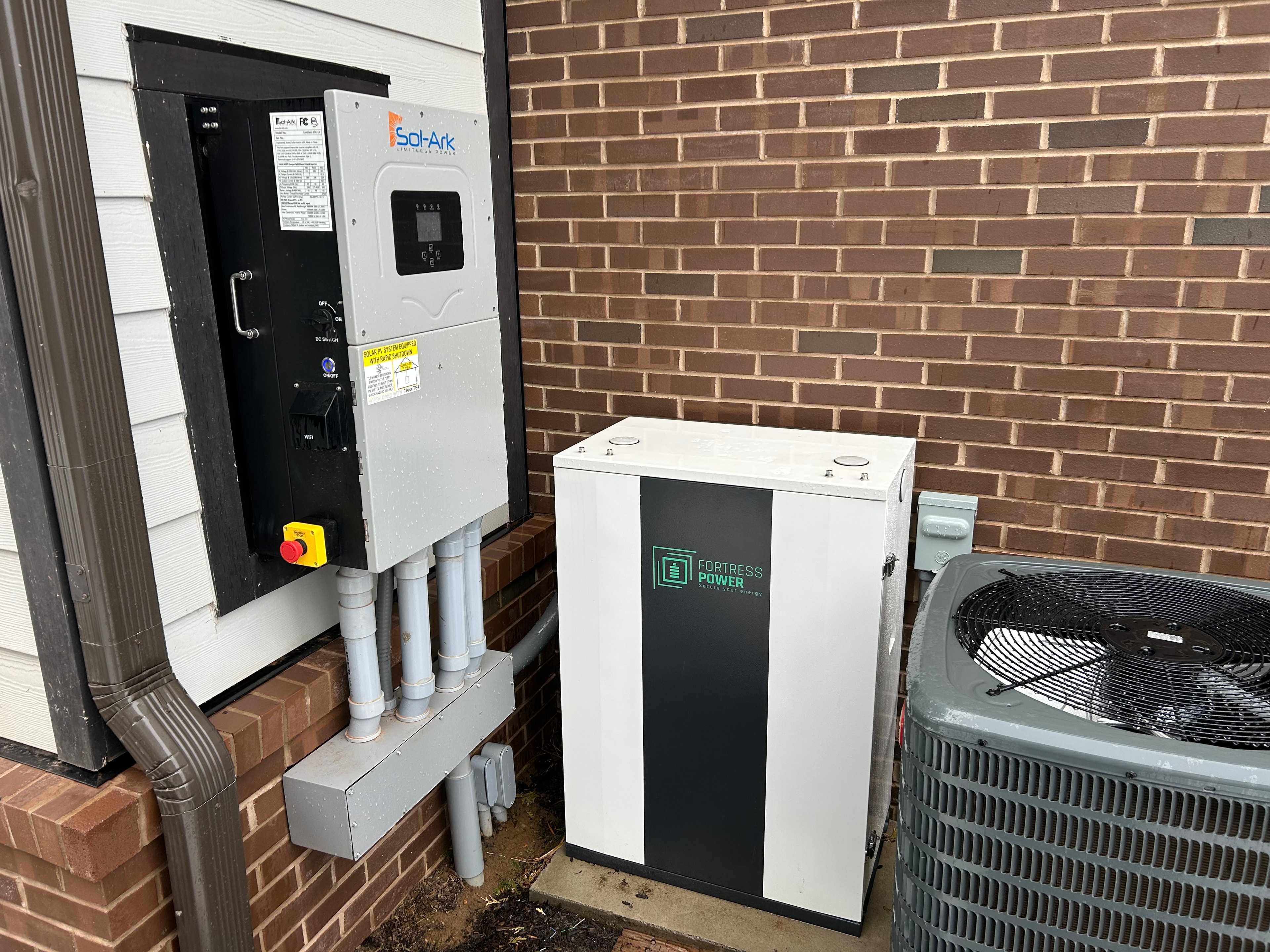 Sol-Ark inverter and Fortress Power battery storage system installed on brick exterior
