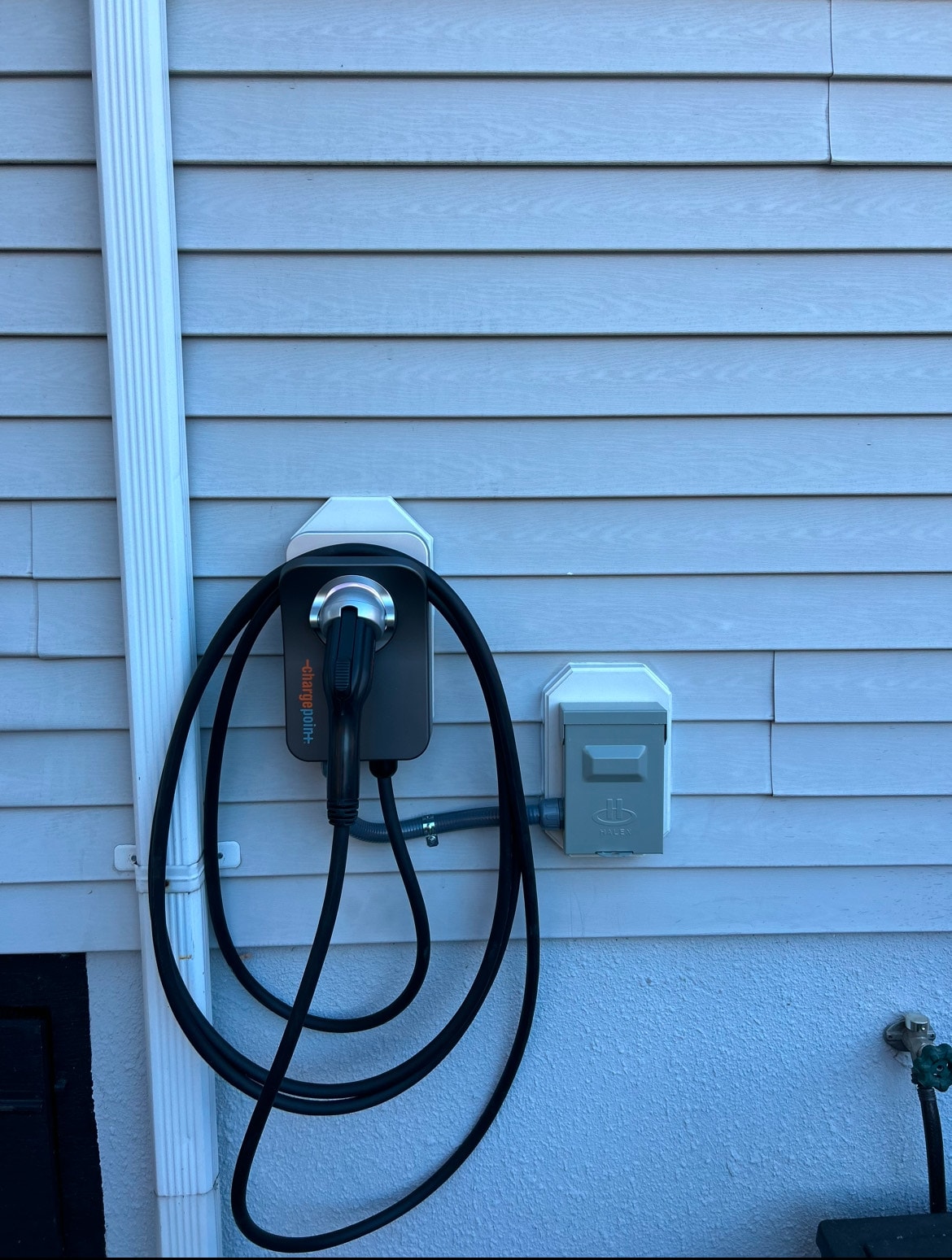 ChargePoint Level 2 EV charger installed on exterior light blue siding