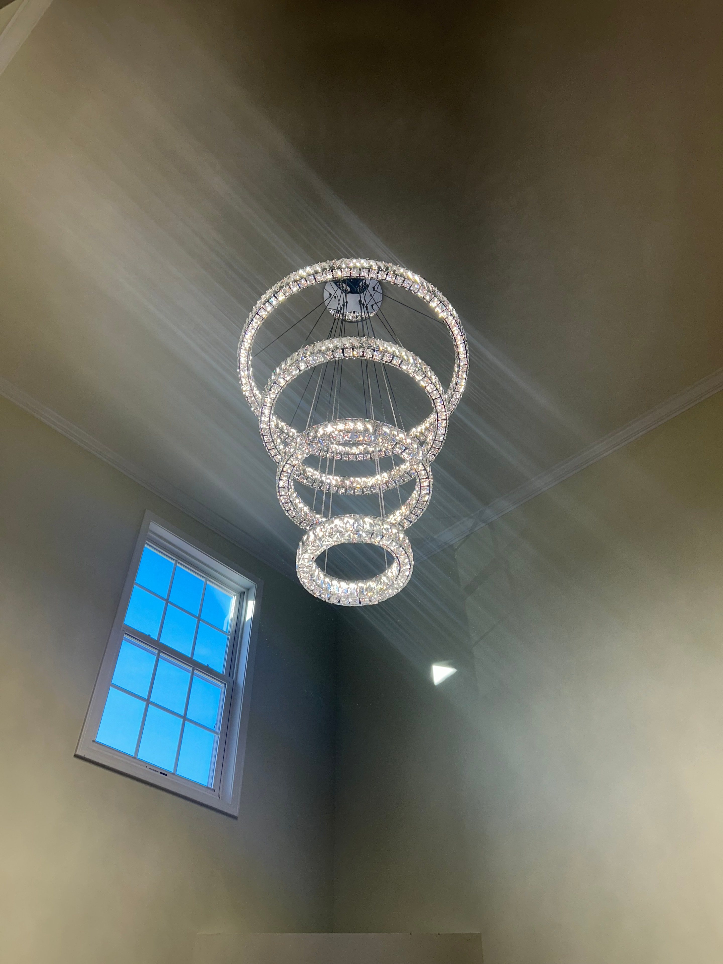 Crystal ring chandelier with skylight in residential foyer